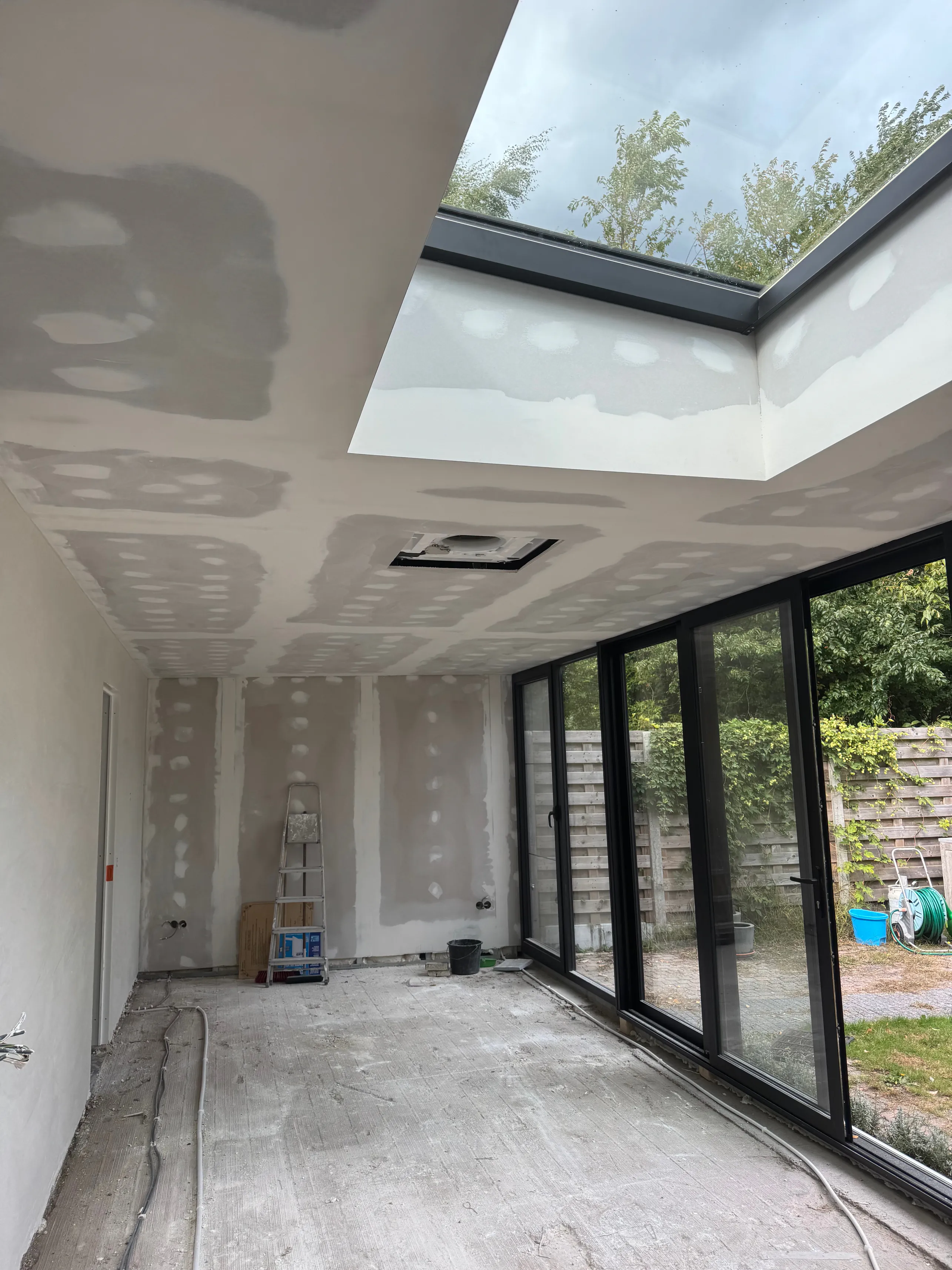 Worker installing drywall indoors (B/W)